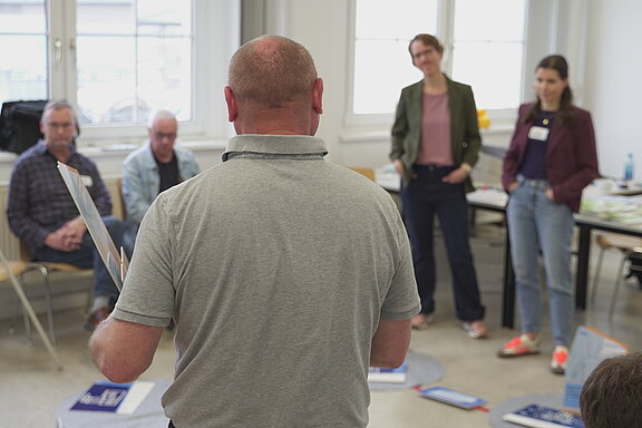 Impression vom Workshop Lieferketten: Ein Mann spricht zu einer Gruppe